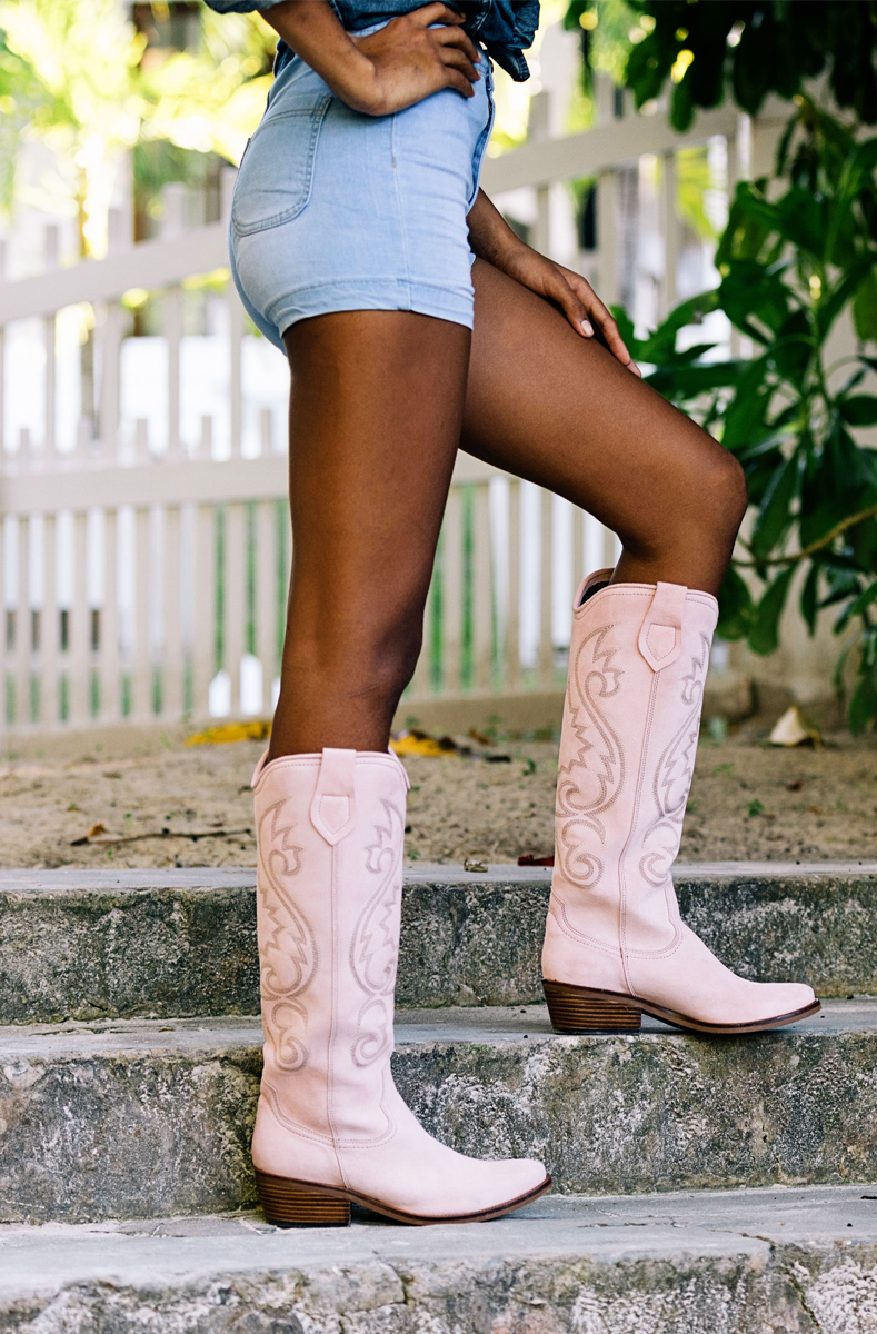 A female model showing a pair of knee high boots